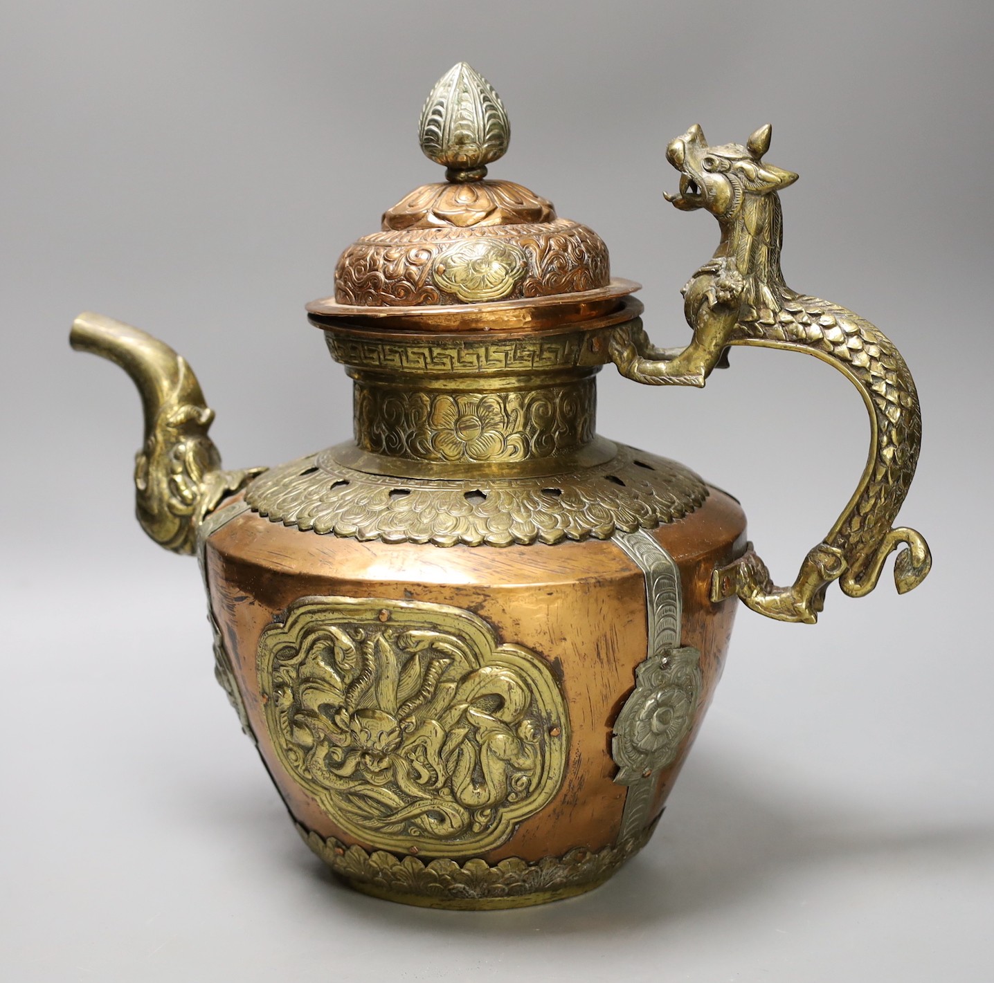 A Tibetan copper and brass ewer with dragon handles, 33cm tall